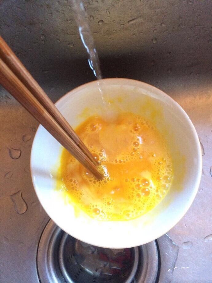 洋葱粉丝炒鸡蛋,加入一勺左右清水搅拌均匀