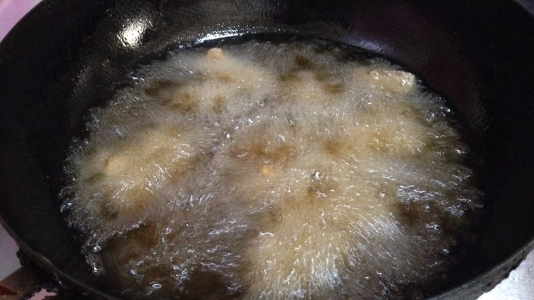 麻辣羊肉,锅内加油烧至4、5成热，分次放入羊肉丁炸制
