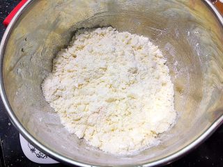 中式三角叉烧酥,中筋面粉倒入盆中加入冻硬后的猪油和糖粉，用手混匀，再倒入配方中的水。