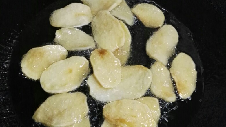 脆皮孜然虾,锅里油烧热抓一把土豆片入锅炸。