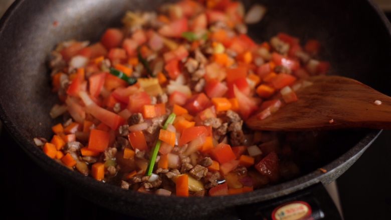 番茄牛肉拌面,待洋葱和胡萝卜稍稍变软后加入番茄丁，翻炒至出汁
