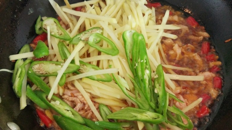 #家常菜大比拼#+青椒土豆肉丝,加入土豆丝和青椒煸炒，加少许盐
