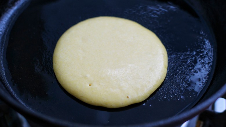 牛奶鸡蛋玉米松饼,舀一勺面糊垂直倒入锅中，待表面出现小气孔时翻面