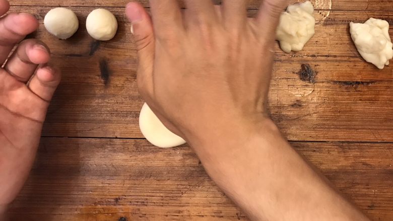 超详细的经典蛋黄酥,⏸将小面团开口朝上，放置在操作面板上，用手轻轻按压，压成饼式。放入保鲜袋中，静置15min。