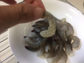 黄金虾球,基围虾去头扯掉虾线，剥去虾壳，虾尾的部分留着。