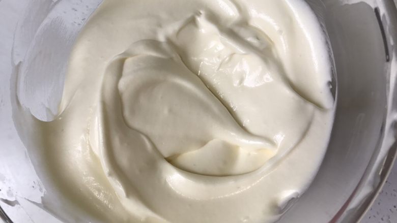 #不一样的泡芙#芒果奶冻泡芙卷,将三分之一蛋白霜加入到蛋黄面糊中，翻拌均匀，再倒入蛋白霜盆中，翻拌均匀。预热烤箱175度上下火。