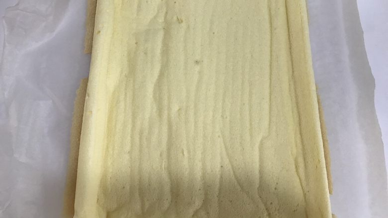 #不一样的泡芙#芒果奶冻泡芙卷,将蛋糕卷平铺，均匀的抹上一层奶油