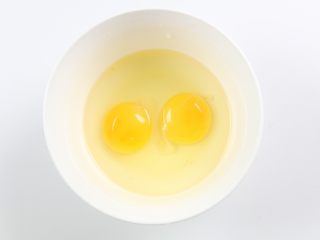 银鱼炒鸡蛋,鸡蛋敲入碗里。