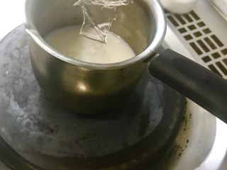 七夕特制-醋栗爱心渐变慕斯,加热牛奶。待牛奶边缘冒泡用手感觉奶锅上方温度，感觉热了关火。将在冷水里泡软的吉利丁片加入热牛奶中，充分搅拌。