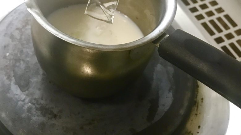 七夕特制-醋栗爱心渐变慕斯,加热牛奶。待牛奶边缘冒泡用手感觉奶锅上方温度，感觉热了关火。将在冷水里泡软的吉利丁片加入热牛奶中，充分搅拌。