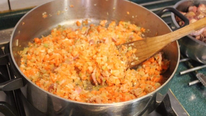 瓦奇诺炖牛尾,倒入蔬菜碎，以小火拌煮，煮至微干。   