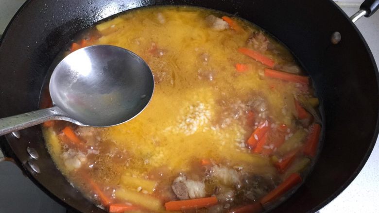 新疆碎肉抓饭,再撒上大米，葡萄干，用勺背把大米推平，水面高出大米1公分；