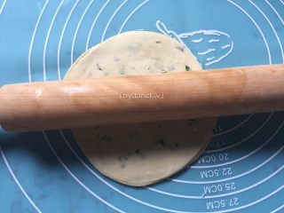 饺子皮葱油饼,然后用擀面杖将叠好的饺子皮擀成又大又圆的一片饼皮