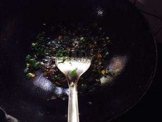 蒜香豆皮金针菇,放入蒜蓉和葱碎放少许生抽熬开出锅