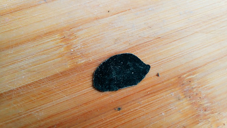 小熊肉松包,黑色面团擀成薄片，用小号裱花嘴的圆口压出圆片。