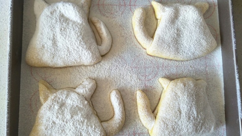 萌萌的猫咪豆沙馅面包,二发酵之后在猫咪的身上，用筛子筛一些高粉上去。