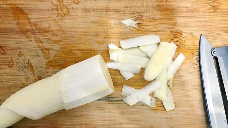 一清二白芦笋茭白炒平菇,如图所示，再用削皮刀削掉尾部的外皮！