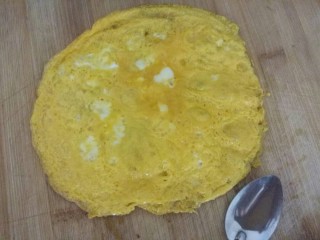 爱心蛋包饭,锅里刷油，倒入蛋黄，摊成蛋黄饼