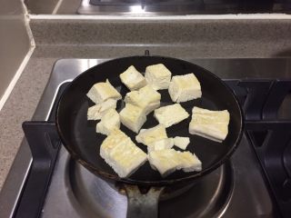 冻豆腐鸡蛋丼,平底锅倒一茶匙芝麻油，均匀抹在锅底。放入冻豆腐，小火煎至金黄，翻面，另一面同样煎至金黄，然后称出来。