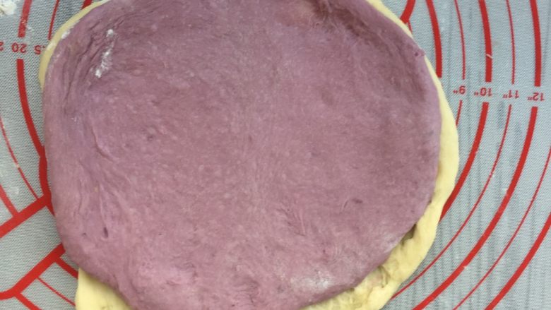 面包机版   紫薯双色吐司,取发酵好的两色面团各一份，擀成面片，原味面片在下，紫薯面片在上，用原味面片将紫薯面团卷入。