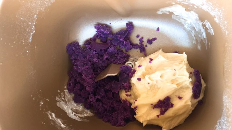 面包机版   紫薯双色吐司,其中小的那一份放入面包机，放入60克紫薯泥，揉成光滑的紫薯面团。
这一步无需揉太久，只要面团和紫薯充分融合就好了。