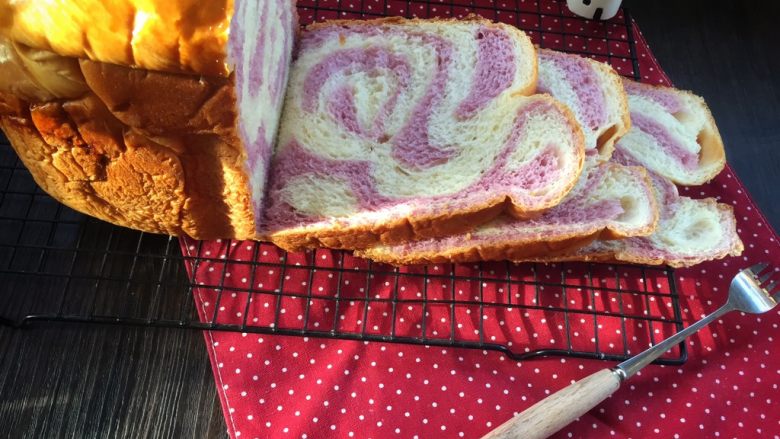 面包机版   紫薯双色吐司,用面包刀切成薄片。
或者用手撕着吃也是非常不错的选择呢。
