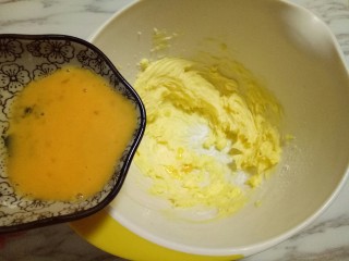 原味曲奇饼干,打至黄油颜色变浅，体积变大，并且形成顺滑的纹路，这时加入三分之一的蛋液，继续电动打蛋器打发，打至黄油和蛋液完全融合。