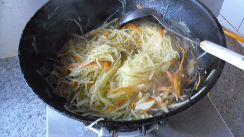 橄榄油小炒, 烹入少许水。翻炒至土豆丝熟透 