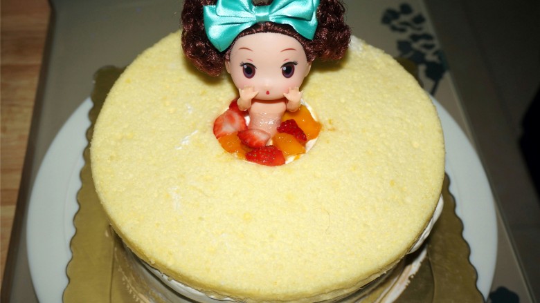 粉色泡浴公主蛋糕,将掏空了中心的蛋糕片放顶层，插入公主娃娃，空隙填上水果。