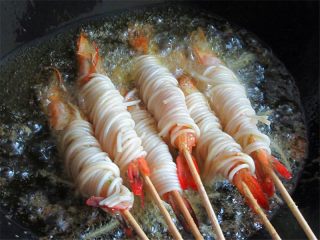 私家茄汁金丝虾串,锅中多注入油，烧至6分热，放入虾串调制中小火炸
