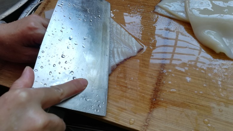 麦穗鱿鱼花,现在开始切鱿鱼花，先用刀在鱿鱼的斜面程45度角下刀，深度是切入鱿鱼的五分之四处，注意不要切断，手法不熟时宁浅勿深。