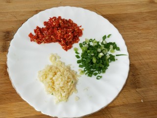 剁椒蒜泥白肉,煮肉的时间将蒜切末，小米椒剁细，葱花切好备用