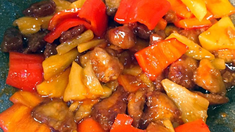菠萝咕咾肉,依次倒入肉块、菠萝和红椒，颠勺炒匀，然后撒盐调味即可出锅了。