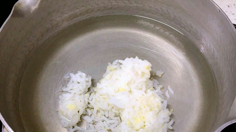 口菇鸡茸二米粥,锅中加入适量的水加入熟米饭煮开