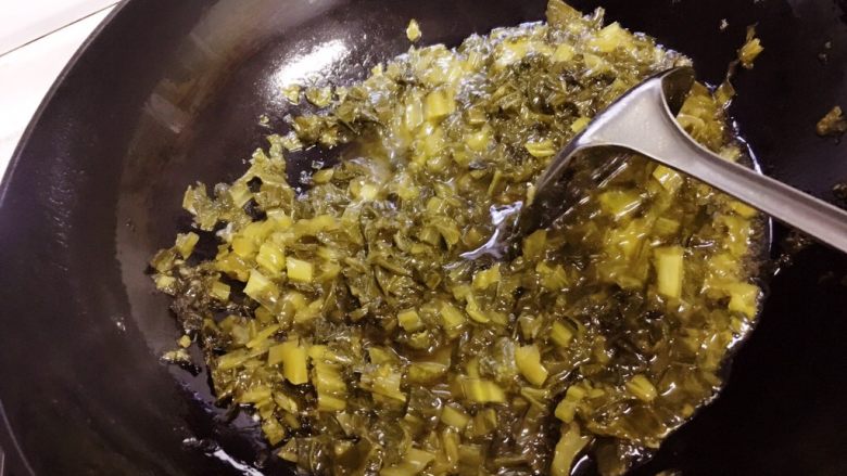 酸菜烧鱼,锅里倒入适量油，烧热后放入酸菜炒香。