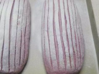 紫薯版麻薯软欧,筛上面粉，用刀片割出条纹。