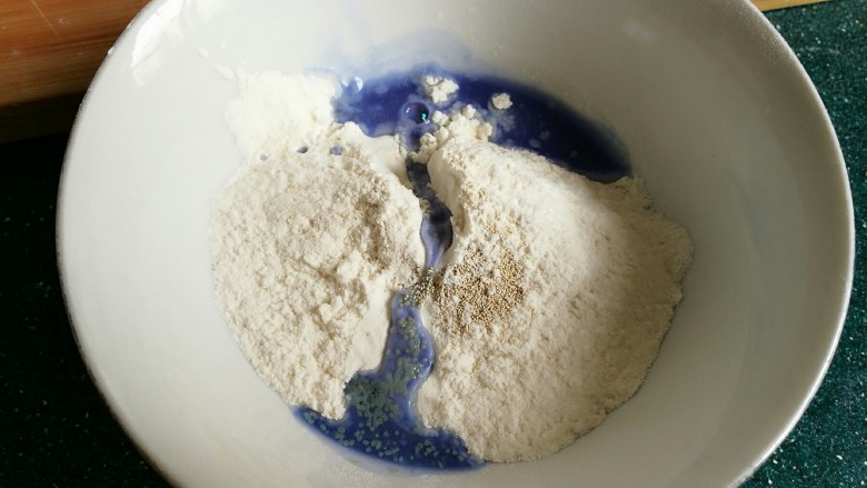 机器猫奶香馒头,另取大约20克面粉，放一点点酵母粉，倒入蝶豆花水和成面团。
