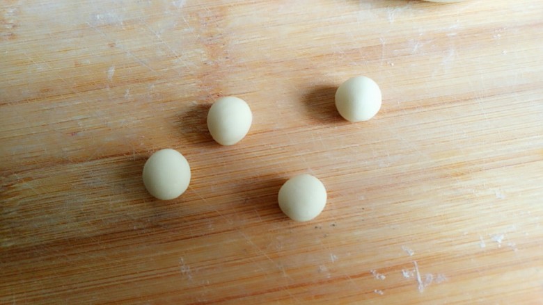 机器猫奶香馒头,用白色面团搓成两个小圆球。