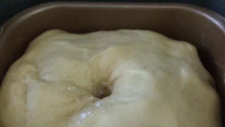 一次发酵吐司面包,启动发酵功能进行发酵至2倍大，手指沾面粉戳面团中间，不回缩如图这样就发酵好了