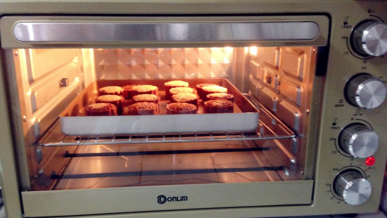 咖啡味桃山月饼,月饼表面刷一层水，放入提前预热到170度的东菱烤箱中层，烘烤十分钟即可。