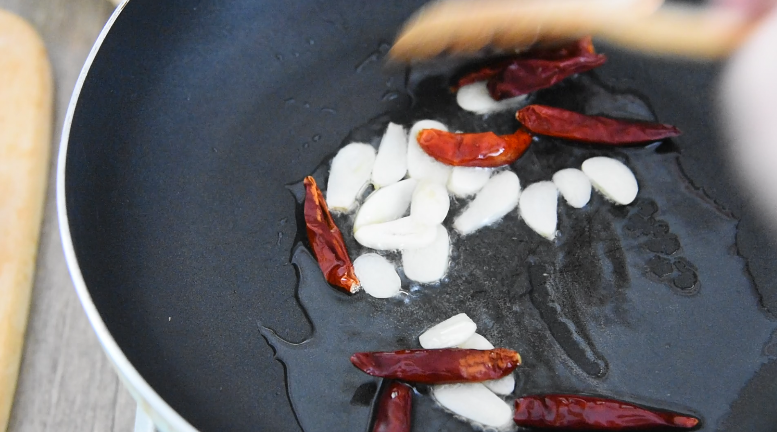 饭店必点的干锅花菜，是这么做出来的！,锅中倒入少许油，爆香蒜片、辣椒干