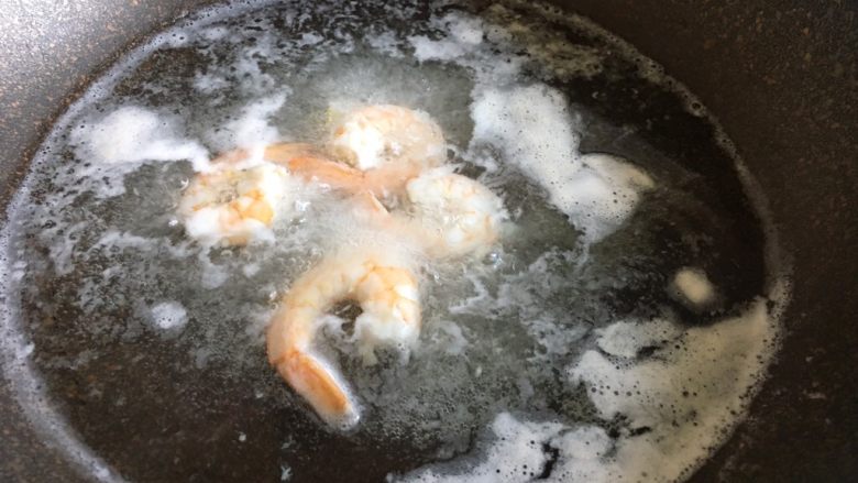 凤尾虾饭团,锅中放入适量盐，加入几片姜，将虾肉煮熟