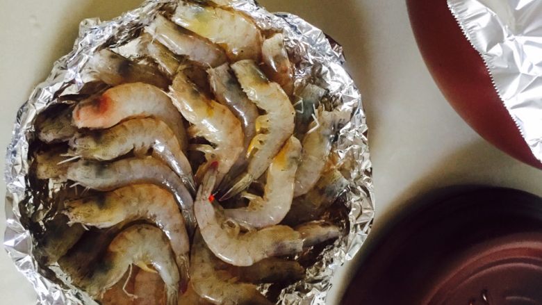 坤博砂锅锡纸蒜蓉虾,用锡纸折成盘子一样的形状，把腌制的基围虾摆进去