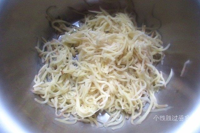 粉蒸土豆丝，小酒必备,撒少许盐腌制20分钟。这时候会腌制一些水处来，找一纱布包住土豆丝，用力把水挤出来。