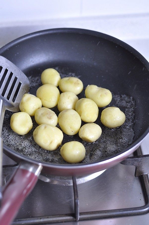 香煎孜然小土豆,炒锅里倒入油，放入土豆，小火煎制。