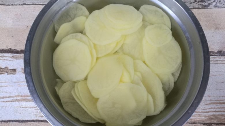 椒盐烤薯片,用清水冲洗四五遍，洗去淀粉质，最后放进清水中浸泡。