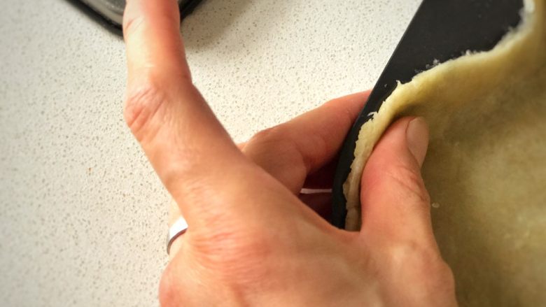 香蕉莓果塔,用手休整好面皮的邊緣，並輕輕往上按壓，讓面皮稍稍高出模貝，以防止烘烤時回縮。