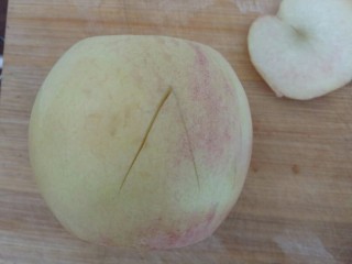 桃的4种吃法,慢慢切对角，切入到桃中心，也就是桃核，方便下一步把它分开两半