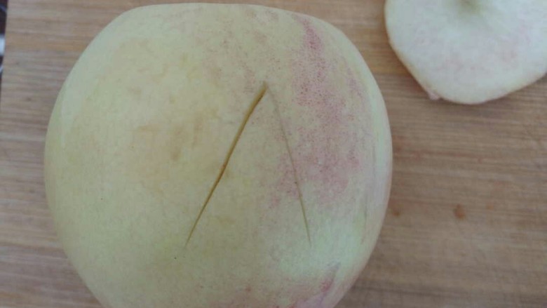 桃的4种吃法,慢慢切对角，切入到桃中心，也就是桃核，方便下一步把它分开两半