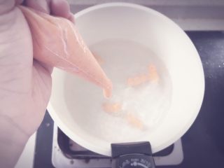 胡萝卜鲜虾条 宝宝辅食,锅中烧水，水开后，将虾泥挤入沸水中，适当长度可以用勺子或者筷子夹断